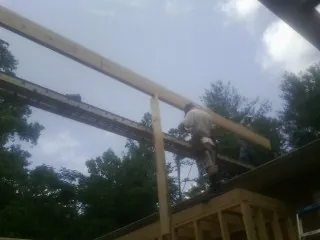 Carpenter setting a ridge beam over a new addition frame — Ice Dam Removal by Roofing Brothers in Mannington