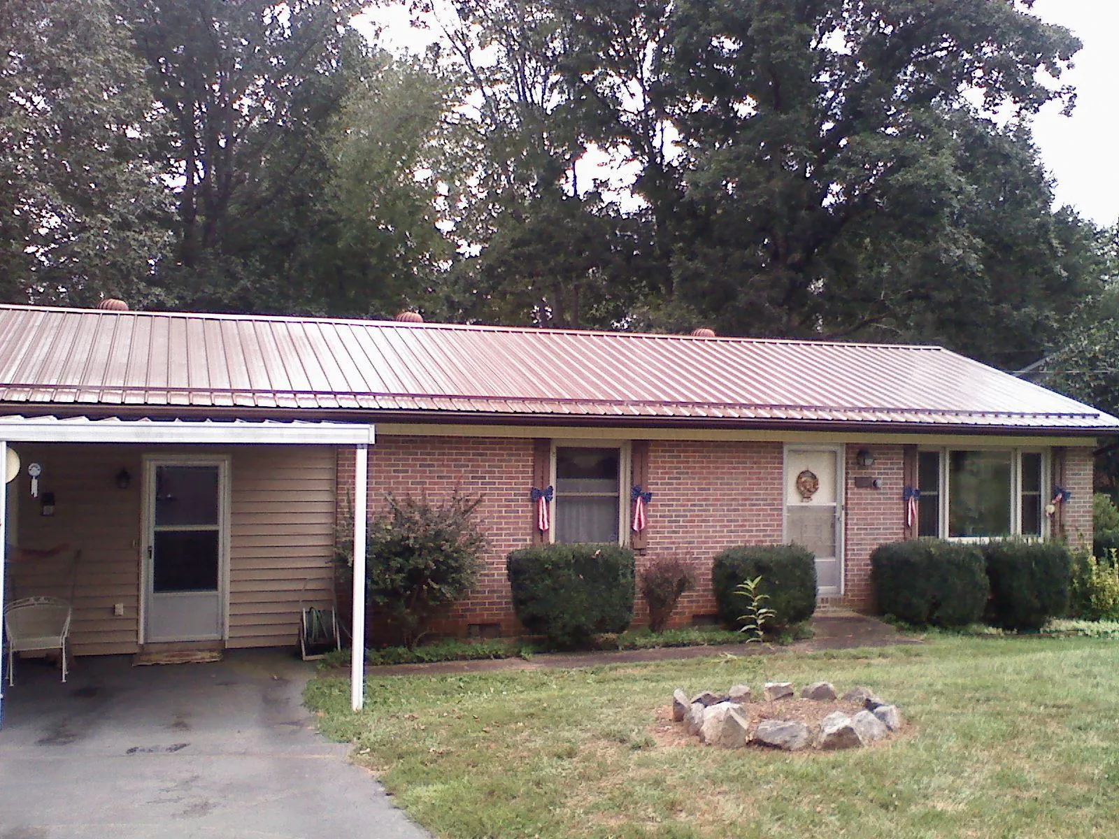 Bronze metal roof and carport on a brick ranch home — Roof Repair work by our crew in Mannington