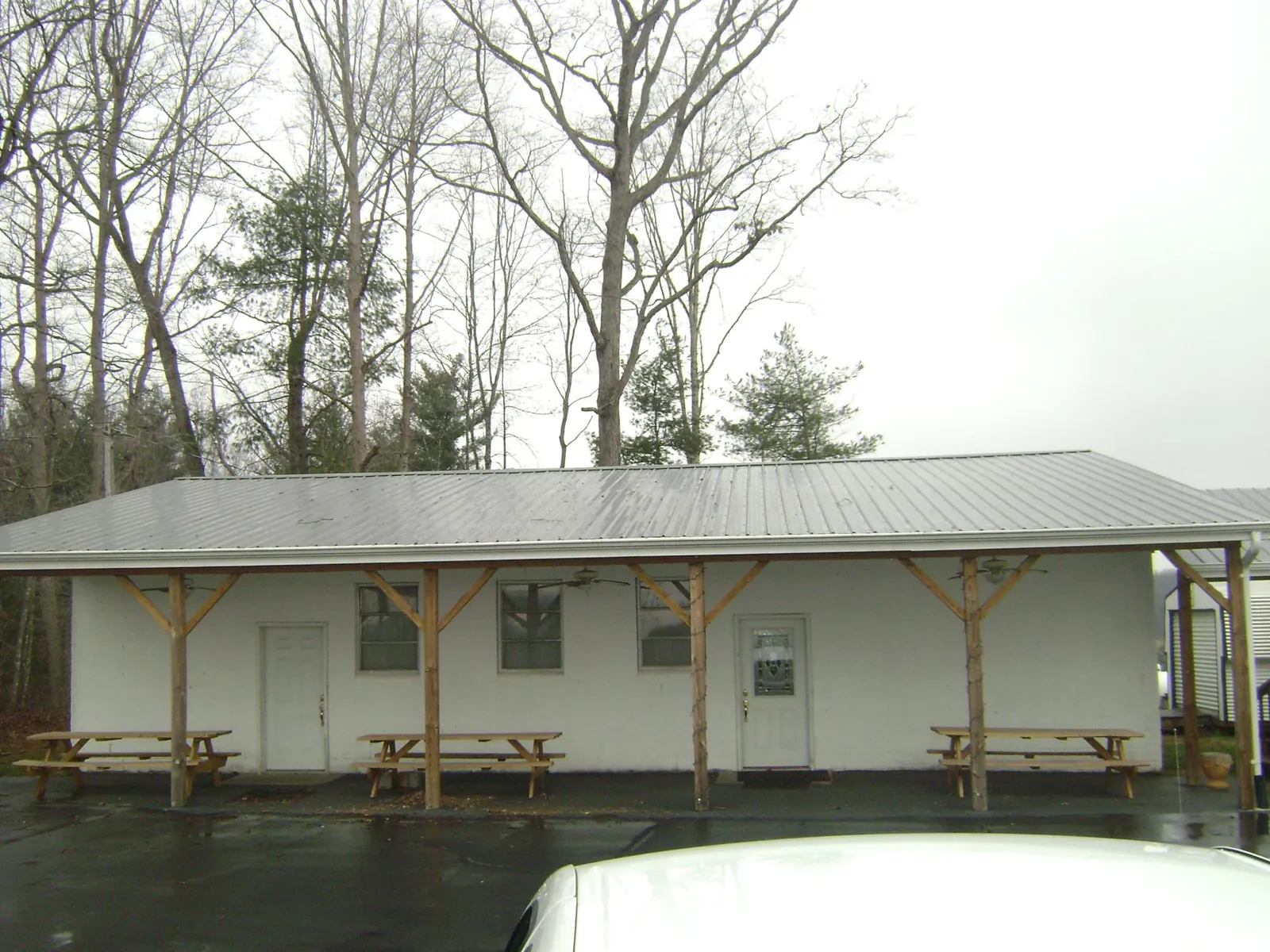 Gray metal roof over a block building with a timber post porch in Mannington